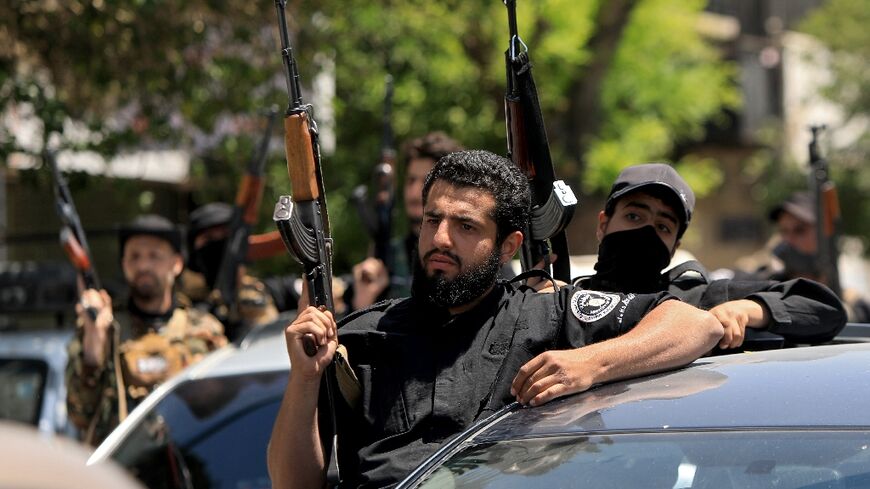 Members of Syria's security forces stand guard in Damascus following overnight sectarian clashes
