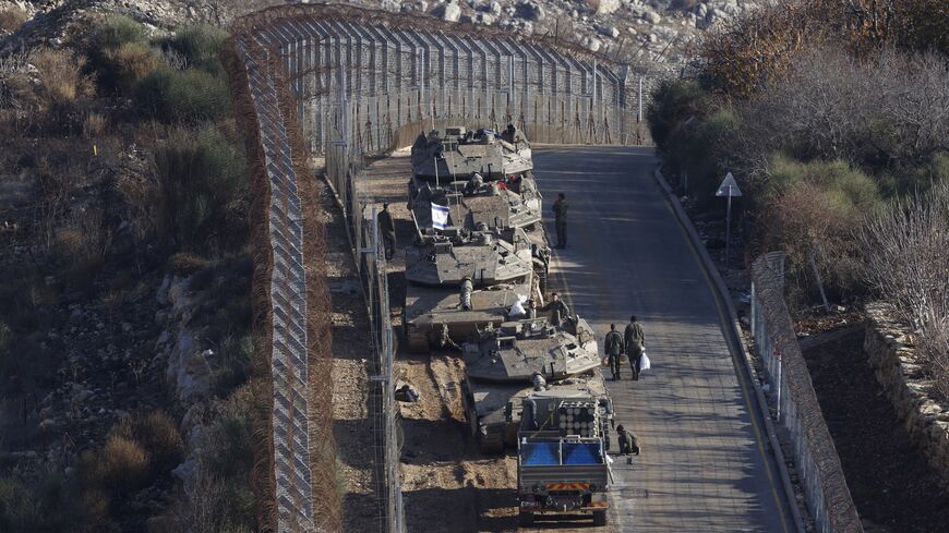 Israeli tanks take position near the fence with the buffer zone that separates the Israeli-annexed Golan Heights from the rest of Syria near the Druze village of Majdal Shams on Dec. 8, 2024. 