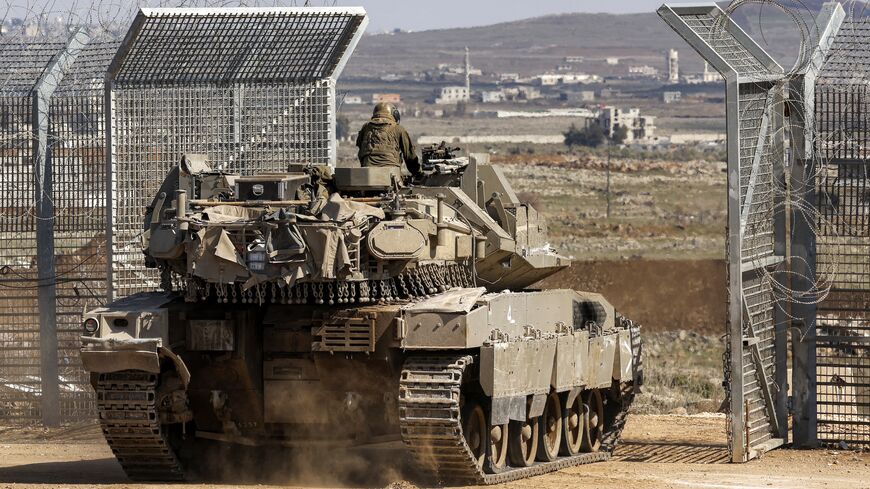 An Israeli army Merkava main battle tank crosses the barbed-wire fence into the UN-patrolled buffer zone separating Israeli and Syrian forces in the Golan Heights near the UN Quneitra checkpoint on March 2, 2025. 