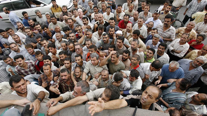 Unemployed Palestinian workers crowd in front of the Palestine Islamic Bank in Gaza to receive a $100 aid from the government appointed by Palestinian President Mahmoud Abbas September 30, 2007. REUTERS/Mohammed Salem (GAZA) - RTR1UFIM