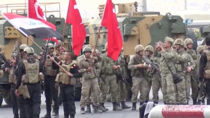Iraqi and Turkish soldiers wave flags at the Habur Border Gate between Turkey and Iraq in this still image taken from video, October 31, 2017. IHA/ via REUTERS ATTENTION EDITORS - THIS IMAGE HAS BEEN SUPPLIED BY A THIRD PARTY. TURKEY OUT. NO COMMERCIAL OR EDITORIAL SALES IN TURKEY. PART NO ACCESS TURKEY.? - RC19E8A7C400