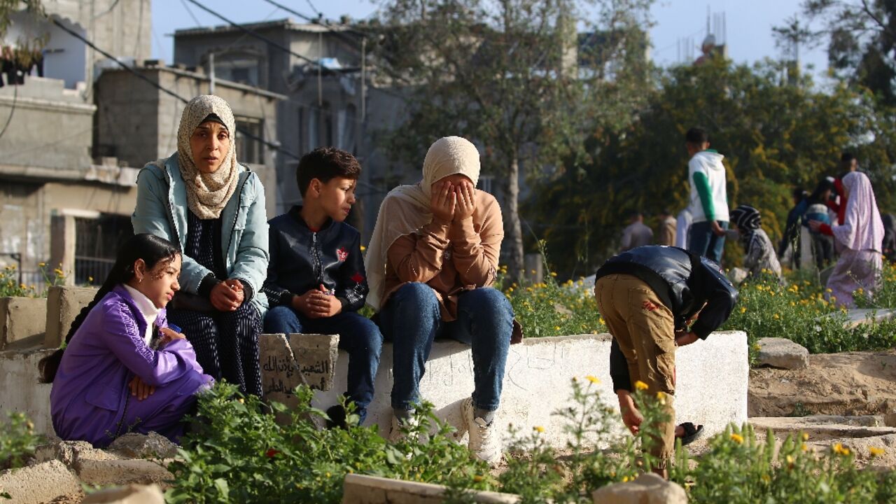 Palestinians visit the grave of a relative after Eid al-Fitr prayers, in the central Gaza Strip Palestinians visit the grave of a relative after Eid al-Fitr prayers, in the central Gaza Strip
