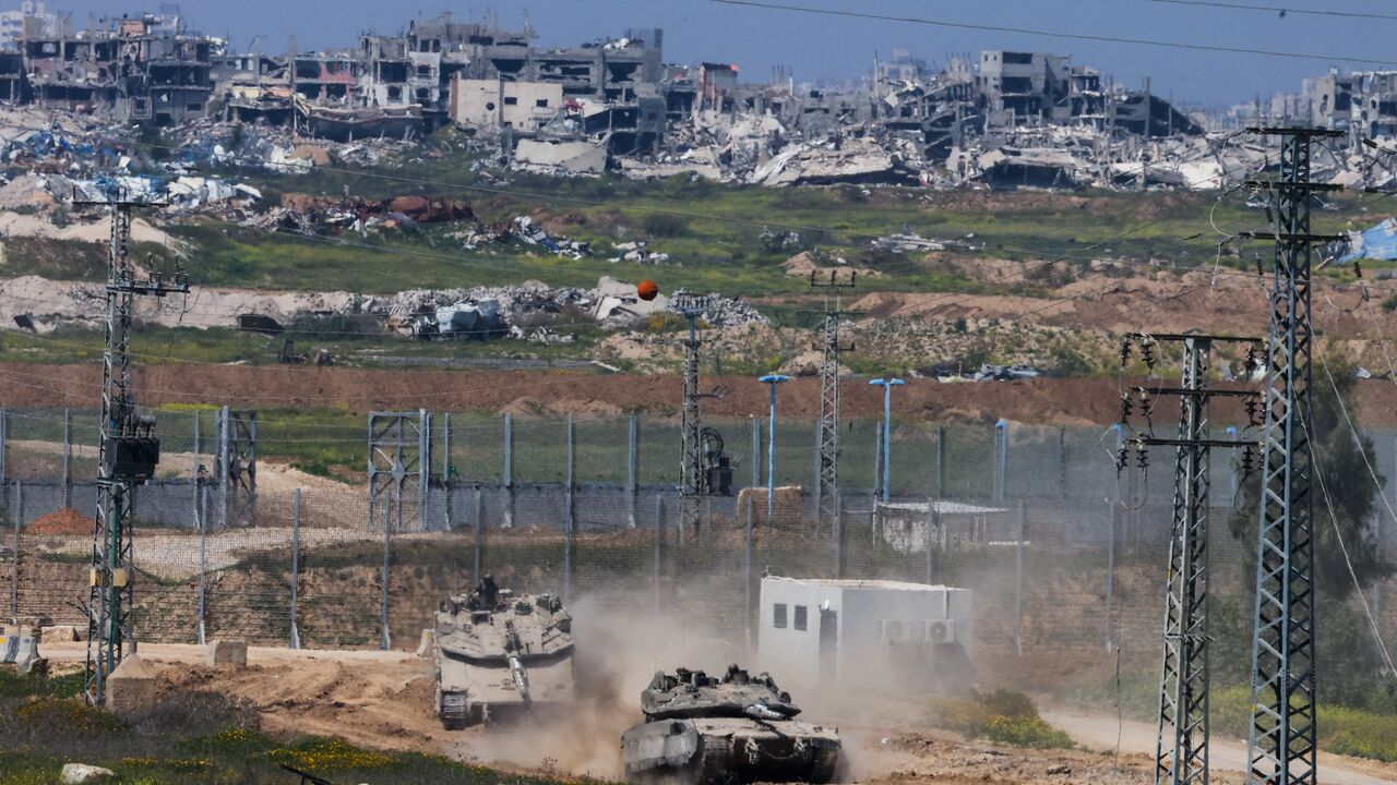 Israeli army Merkava main battle tanks move at a position in southern Israel along the border fence with the northern Gaza Strip on March 18, 2025.