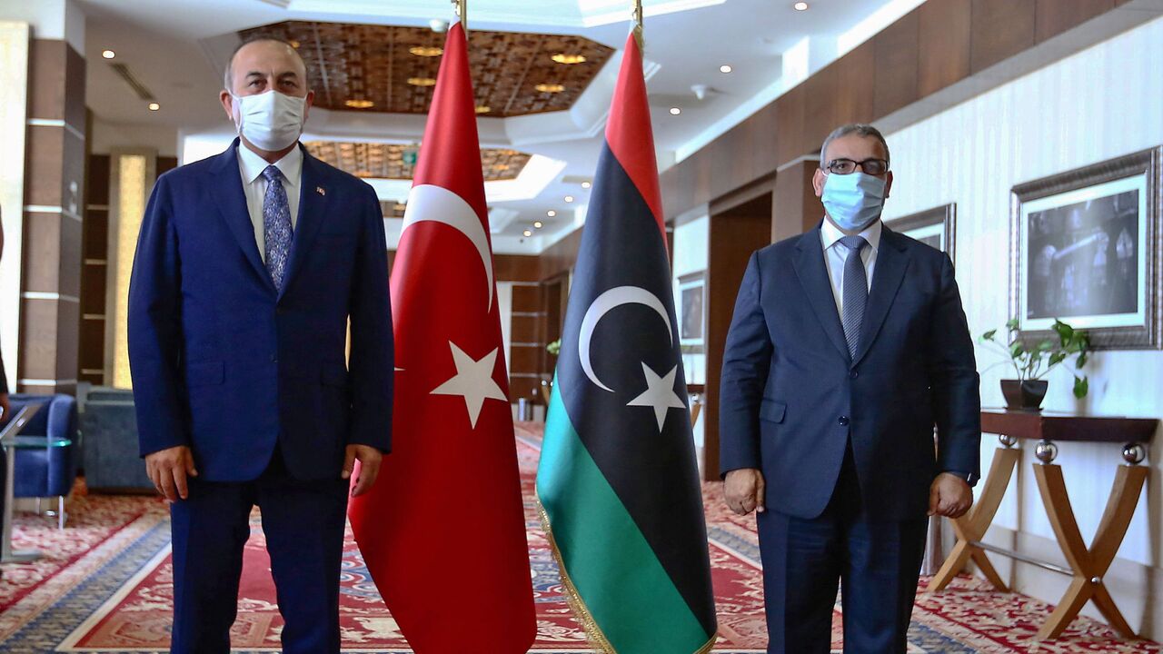 1227935278 Turkish Foreign Minister Mevlut Cavusoglu (L) poses with the President of the Libyan Supreme Council of State Khalid Al-Mishri prior to a meeting in Libya's capital Tripoli, on August 6, 2020. (Photo by - / AFP) (Photo by -/AFP via Getty Images)